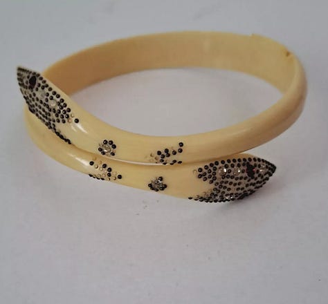 Stylized snake forms beginning in horn or shell are remade in early plastic approximations of natural materials.