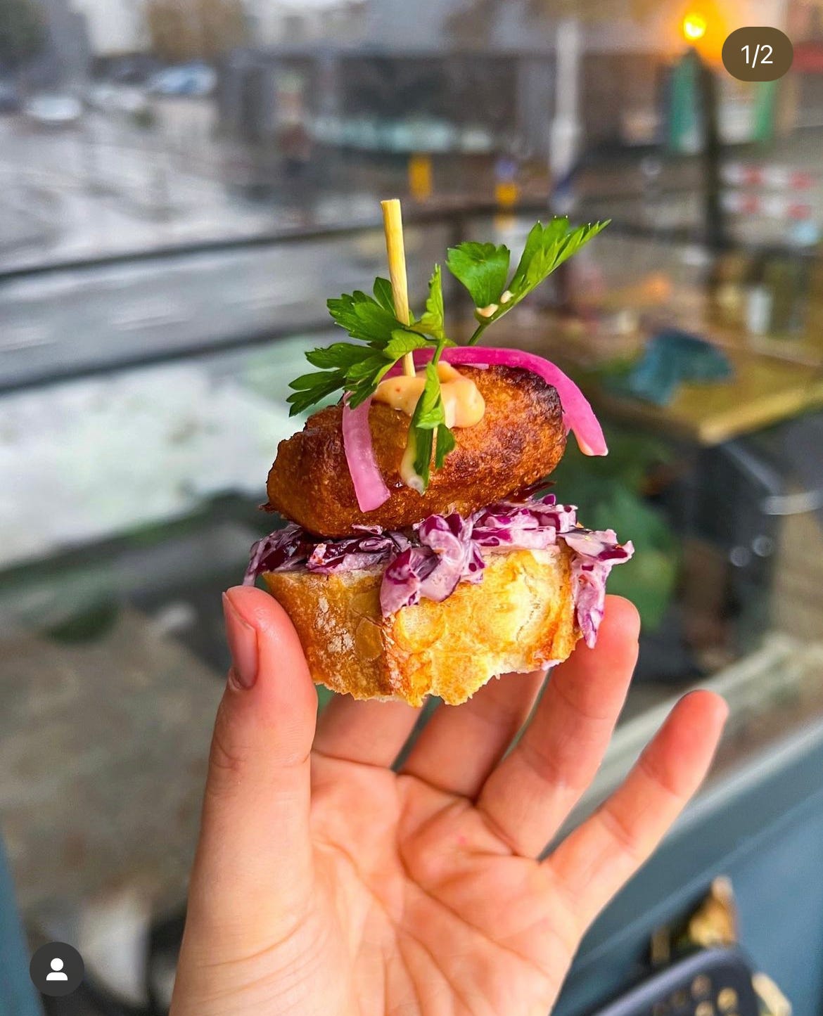 Pincho met krokante kibbeling, pittige rodekool-slaw en sriracha-mayo, gegarneerd met roze ui en verse peterselie, geserveerd met partjes limoen.