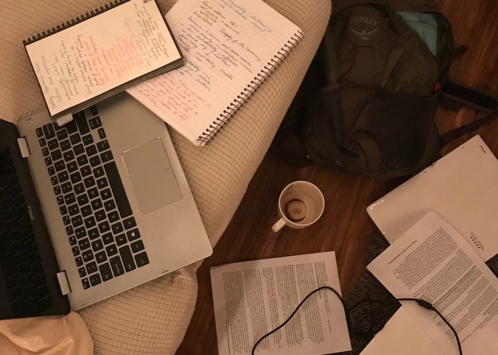 Picture shows a disorganized couch with an empty coffee cup. 