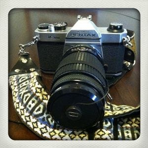 A camera with a strap attached to it

AI-generated content may be incorrect.