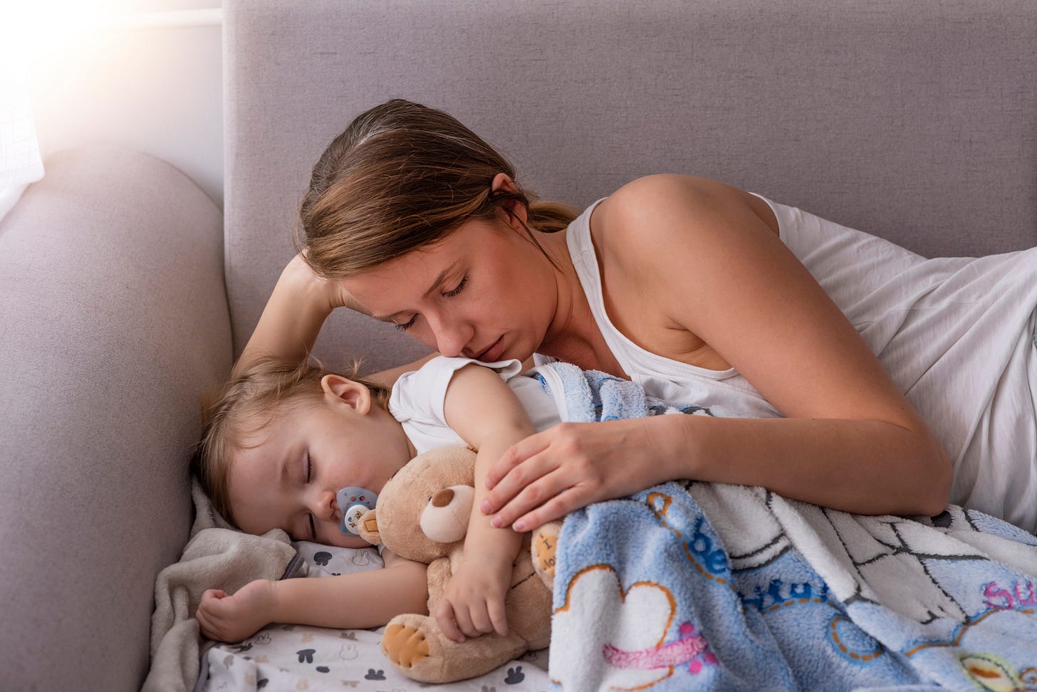 Sleepy mom with baby on couch. Sleepy mom with baby on couch.