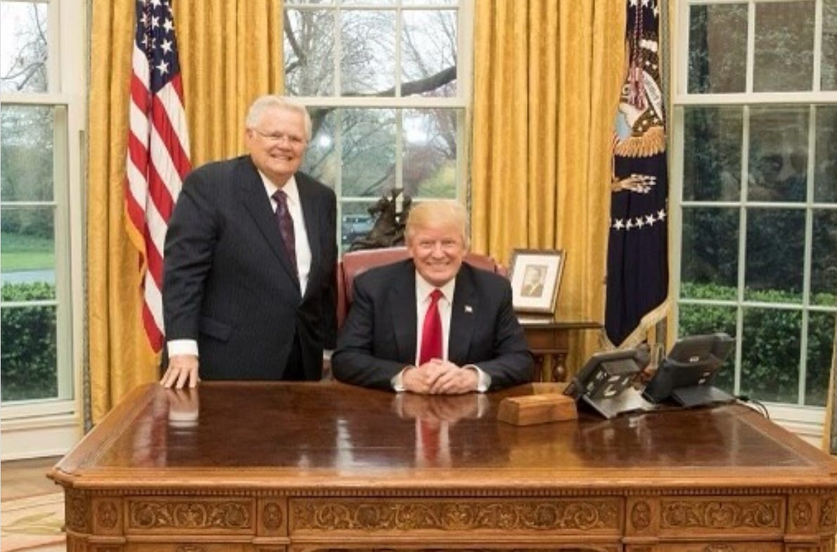 John Hagee, foundish grey haired man in suit, standing beside Trump grinning at desk in oval office; posted Instagram 2024
