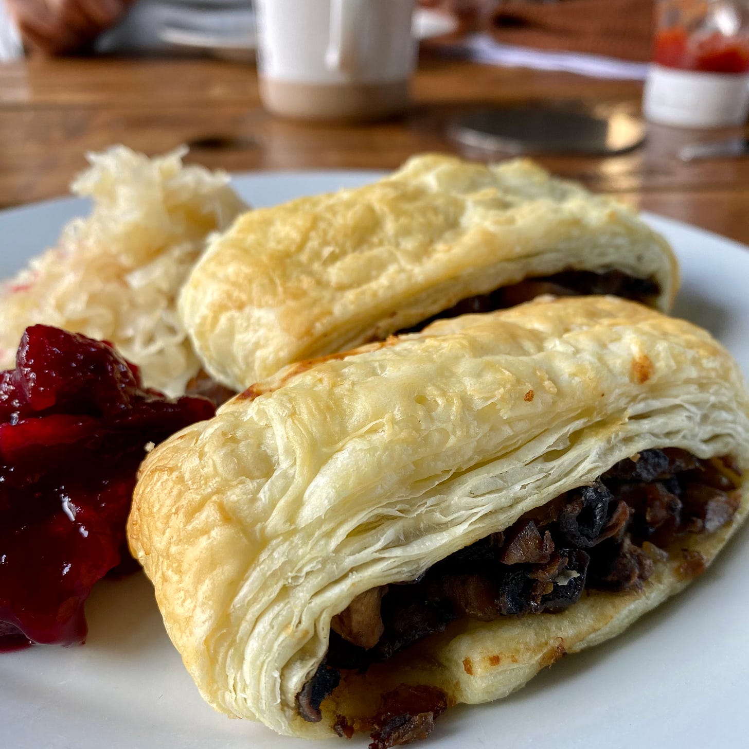 Mushroom & Chestnu vegan sausage rolls on a plate with cranberry sauce