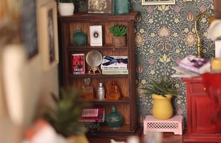 Close up images of the miniature room. Books Amber has written, the "Y: The Last Man" graphic novel, a photo of her husband, a typewriter, and tarot cards can be seen.