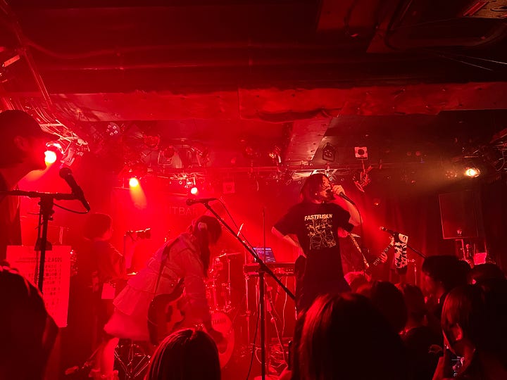 left: staircase to music venue right: punk band playing on stage bathed in a red glow