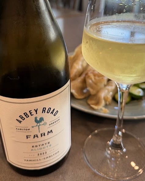 Three wines reviewed: Tiberio Cerasuolo d'Abruzzo poured in a deep pink glass beside its bottle, Approachment 2023 Pinot Meunier Traditional Method Sparkling in a stemmed glass, and Abbey Road Farm 2023 Estate Aligoté poured alongside a plate of dumplings