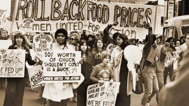 Protesters march carrying signs decrying food costs. Protesters march carrying signs decrying food costs.