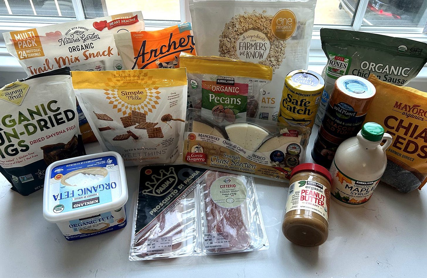 Costco groceries spread on a kitchen counter with the product labels facing forward, including One Degree sprouted oats, Safe Catch and Wild Planet tuna, Kirkland organic feta and a Garcia Baquero Spanish sheep and goat cheese selection. Costco groceries spread on a kitchen counter with the product labels facing forward, including One Degree sprouted oats, Safe Catch and Wild Planet tuna, Kirkland organic feta and a Garcia Baquero Spanish sheep and goat cheese selection.