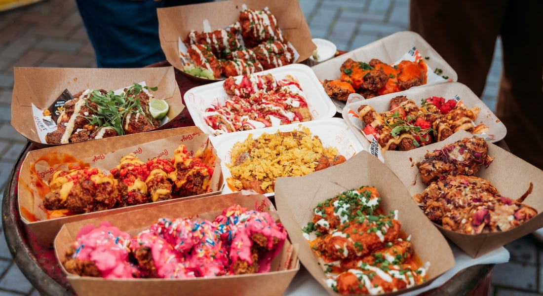 A table filled with boxes of wings with various toppings