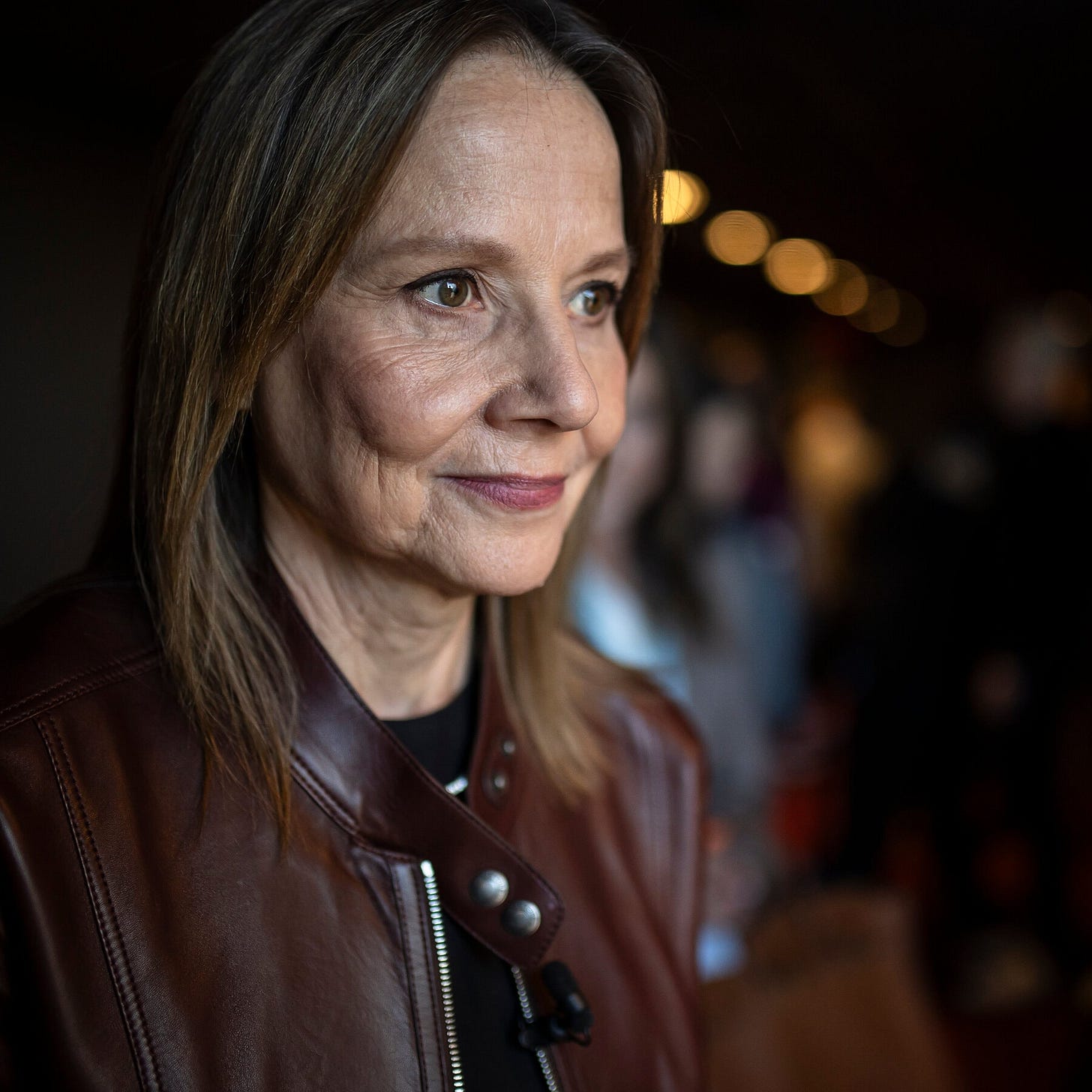 A portrait of Mary Barra, who is dressed in a brown leather jacket. 