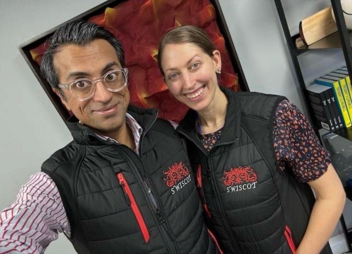Photo of me and my husband Vikas wearing matching black sleevless Gilets with the Swicot logo embroidered. Looking matching in our outfits. Photo of me and my husband Vikas wearing matching black sleevless Gilets with the Swicot logo embroidered. Looking matching in our outfits.