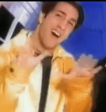 Still frame of Joey smiling big with his hands up near his shoulders