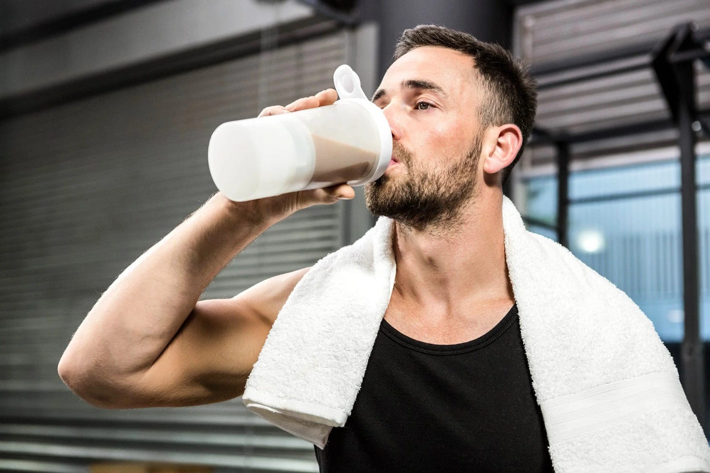 Fit man drinking milk and protein post workout. 
