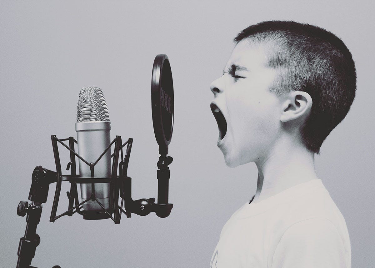A boy shouting into a microphone