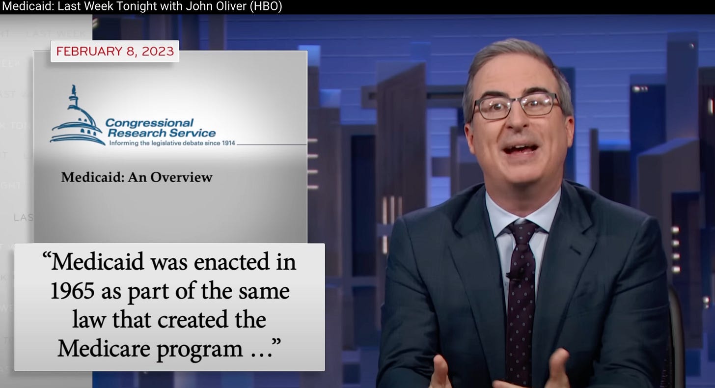 A screenshot from Last Week Tonight with John Oliver. Oliver sits at the anchor desk mid-sentence, hands raised, in front of the show's blue city-skyline backdrop. Beside him, a graphic shows the Congressional Research Service logo and its tagline about informing the legislative debate since 1914, above the report title "Medicaid: An Overview," dated February 8, 2023. Below that, a pull quote from the report reads, "Medicaid was enacted in 1965 as part of the same law that created the Medicare program …"