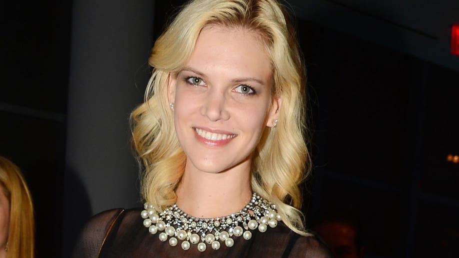 Nadia Marcienko in a black dress with a pearl necklace