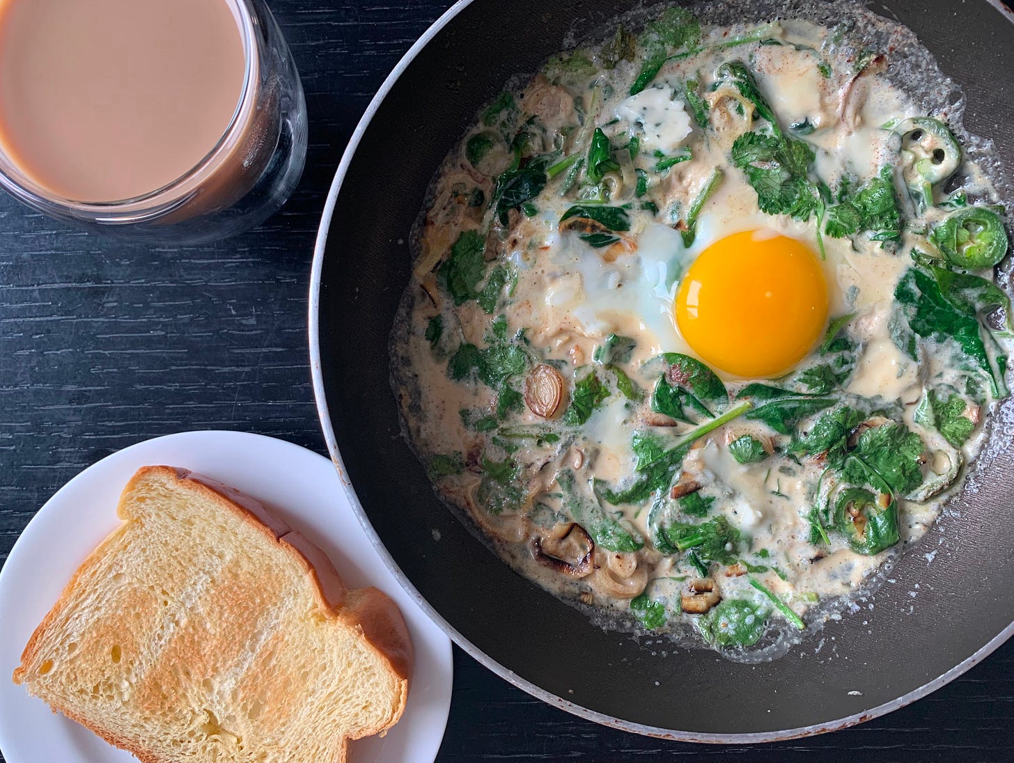 Creamy green shakshuka with spinach, jalapeños, leeks, and fresh herbs, topped with a sunny-side-up egg. Served with toasted challah bread and a glass of coffee. Part of Liat Portal’s Foodie Disorder journey on The Liat Show.