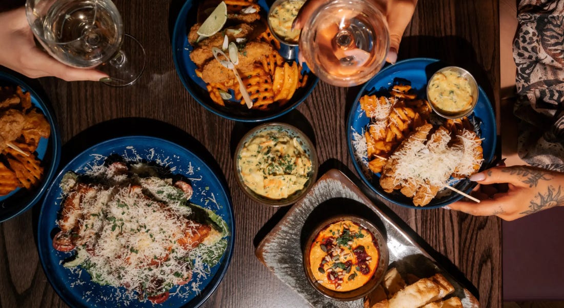 A birds eye view of a table with blue plates with cheese, chips, and drinks on it A birds eye view of a table with blue plates with cheese, chips, and drinks on it