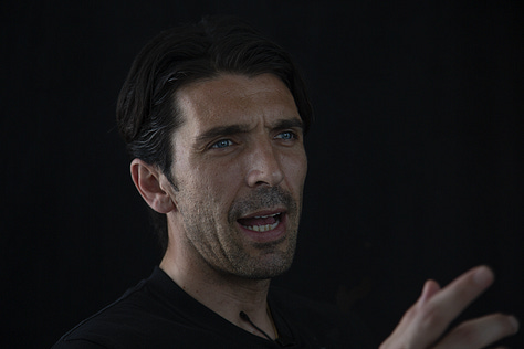 Gianluigi Buffon during a filmed interview on May 12, 2012: shown smiling, speaking, in profile, gesturing with emphasis, and seated against a black background.