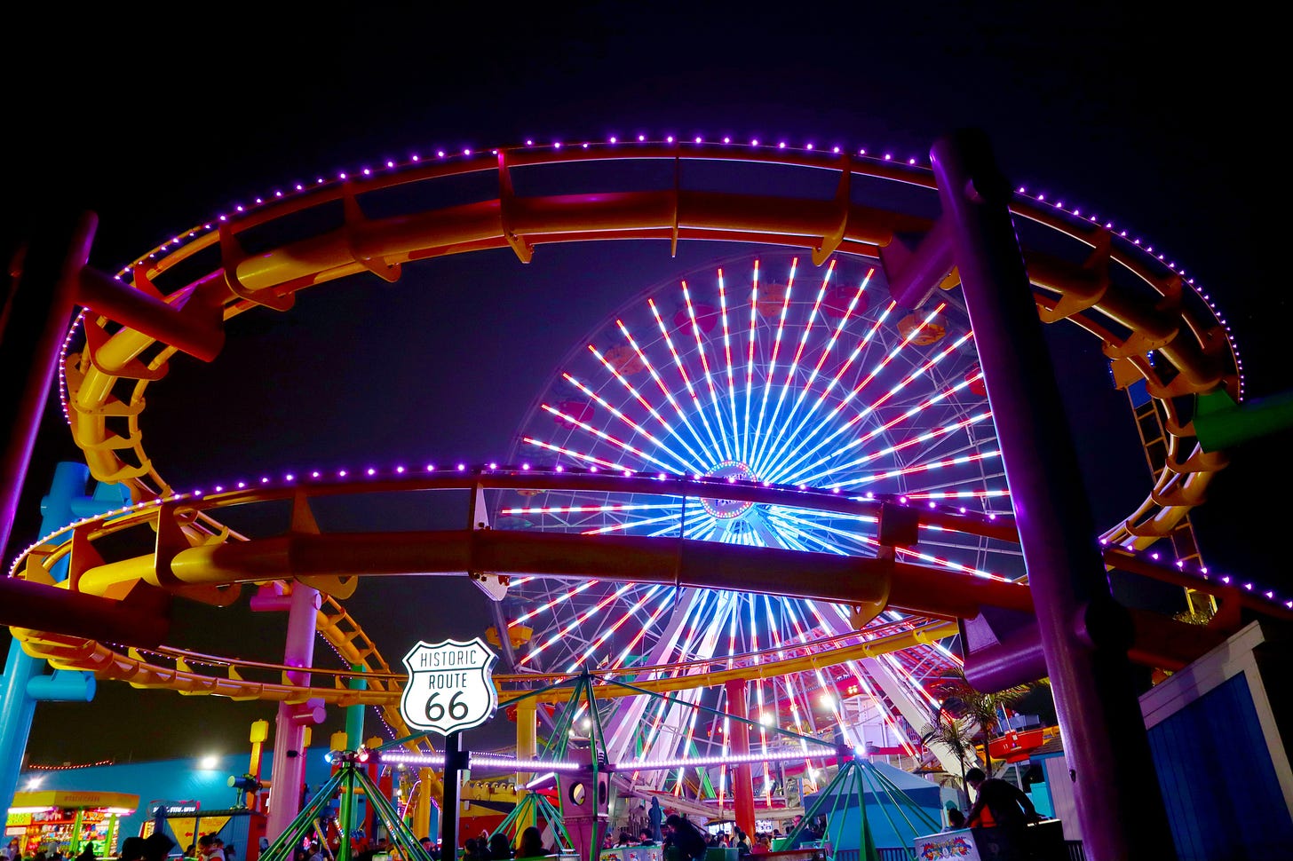 Colourfully lit fairground rides at night