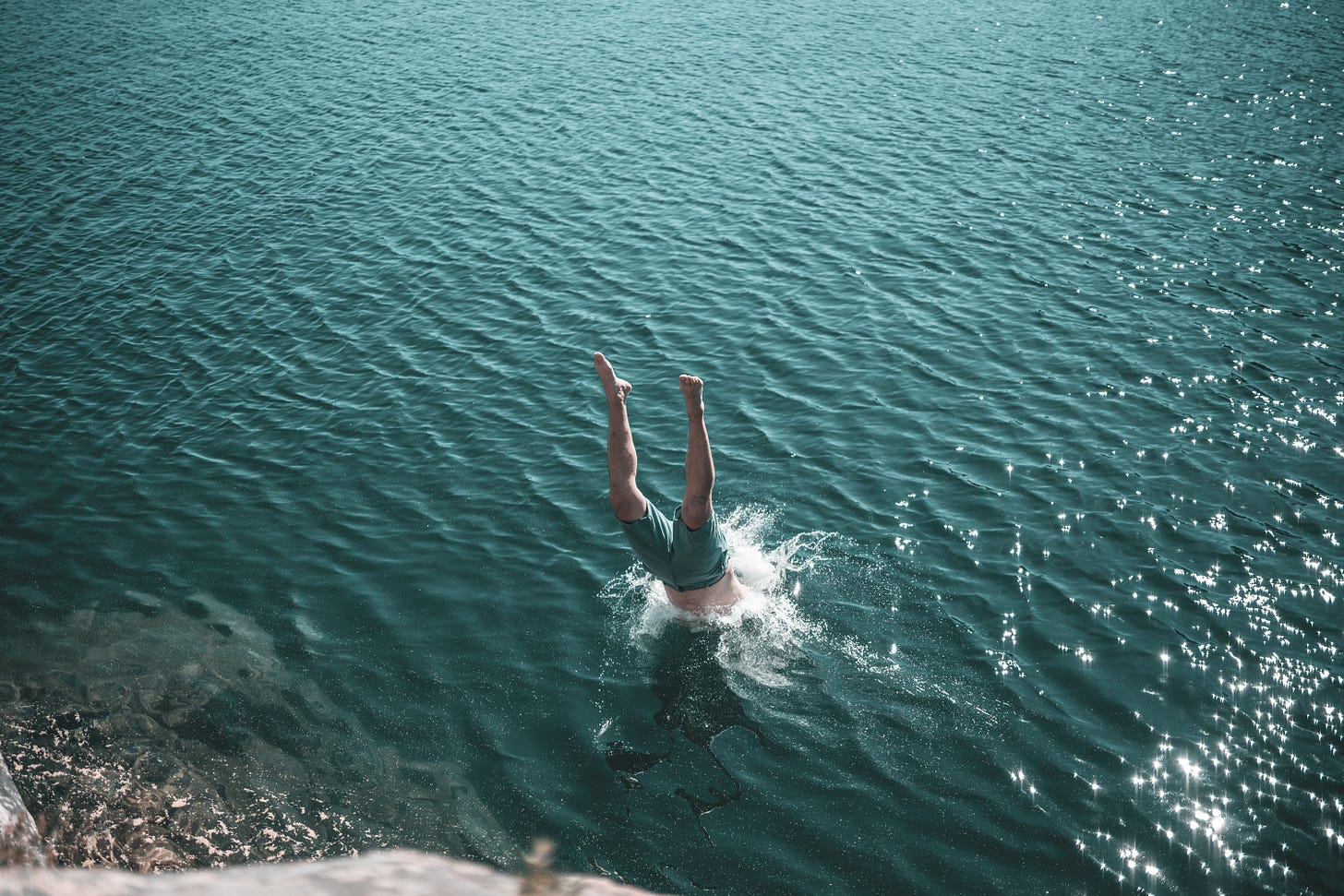 Person diving headfirst into water Person diving headfirst into water