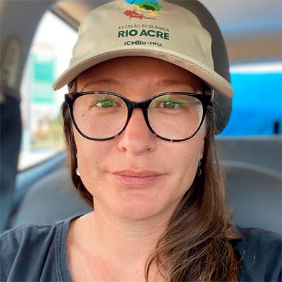 Mulher de óculos usando boné, com uma blusa cinza, no interior de um carro Mulher de óculos usando boné, com uma blusa cinza, no interior de um carro