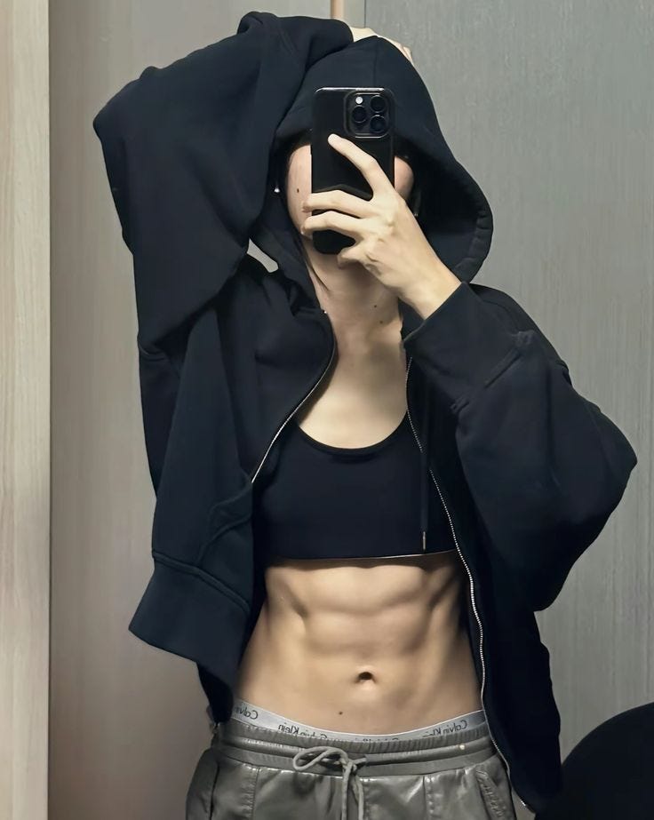  Ia mengenakan jaket kulit hitam yang dibiarkan terbuka, menampakkan crop top abu-abu ketat yang memamerkan lekuk pinggang ramping berotot, dipadu legging hitam pekat yang membungkus kaki jenjangnya dengan begitu pas