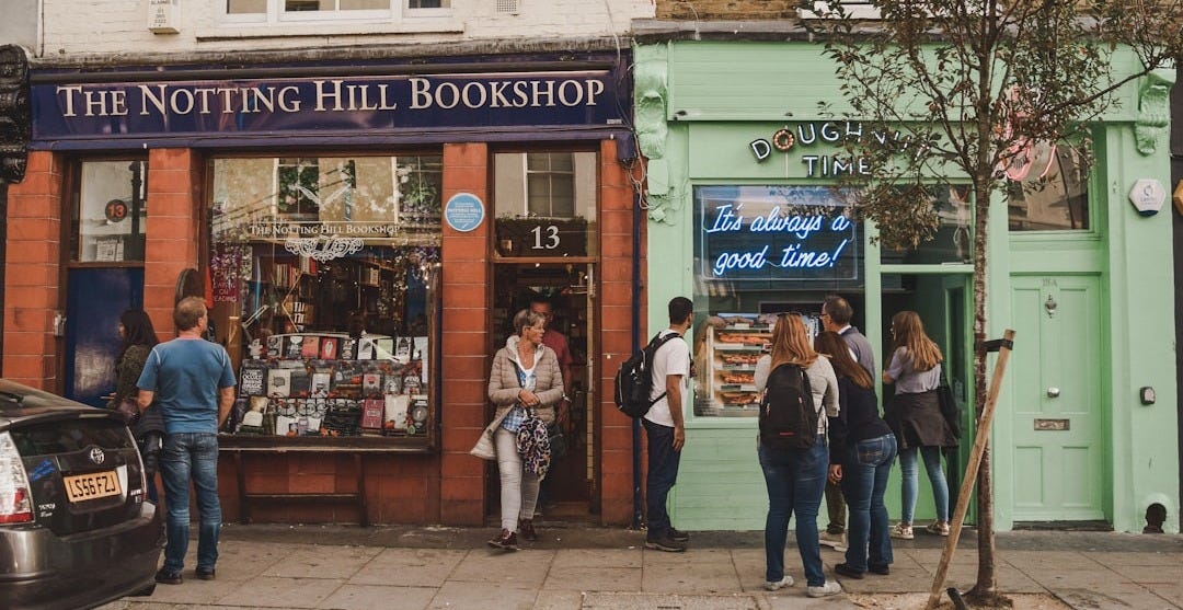 people walking on sidewalk near UNKs store during daytime