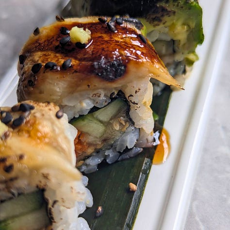 Eggplant unagi three ways: sushi rolls with avocado and torched topping, a modern sushi bowl with vegetables and plant-based egg, and a chirashi bowl with cucumber, egg shreds, and carrot caviar.