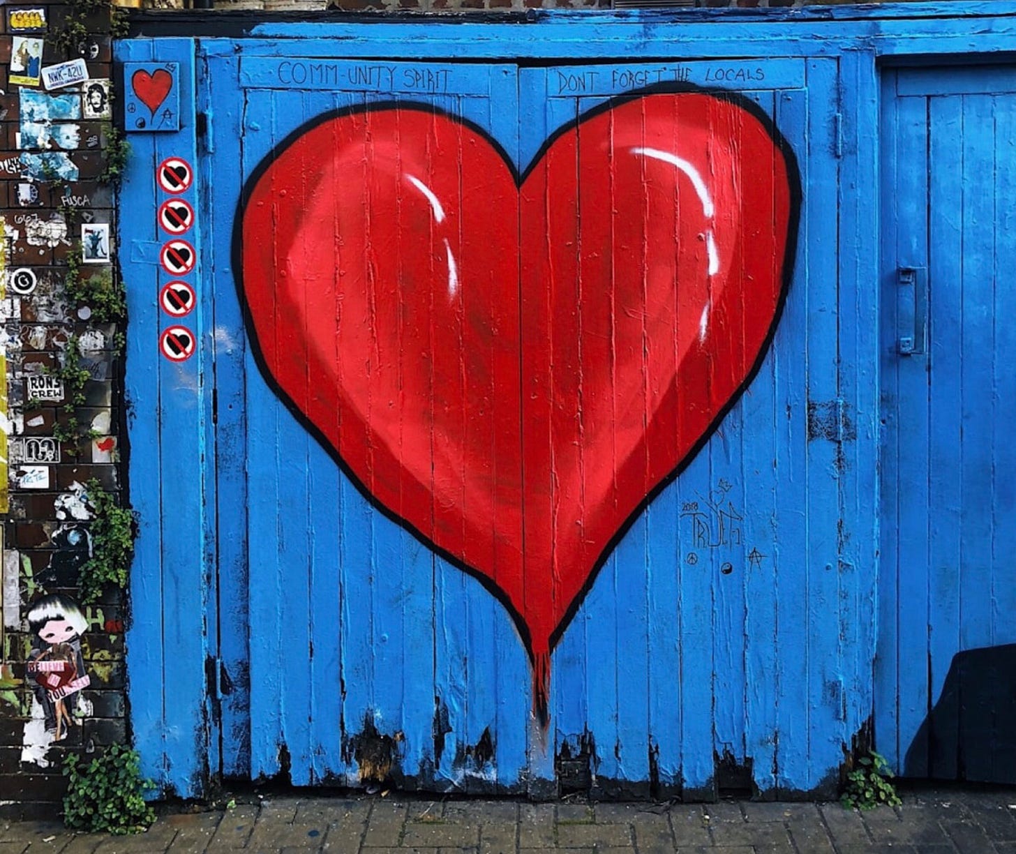 a large red heart painted on a blue building