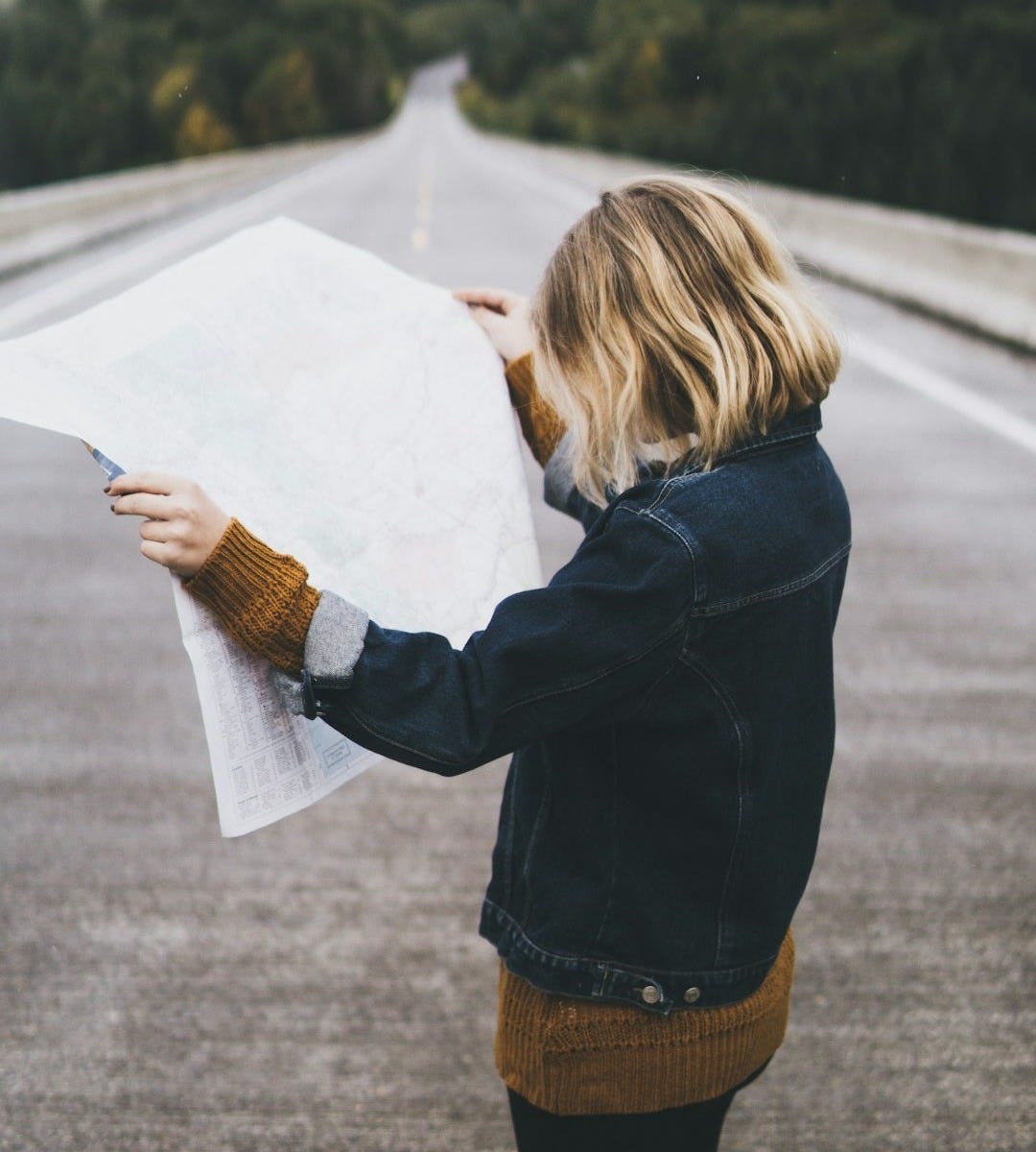woman looking at map while standing on road woman looking at map while standing on road