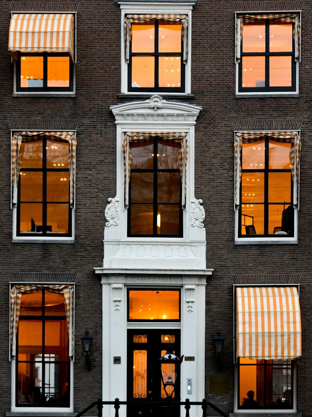 a tall building with many windows and awnings