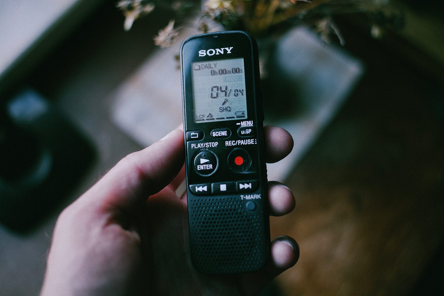 Рука держит диктофон Sony ICD-PX333 с экраном, на котором отображается время записи и статус.