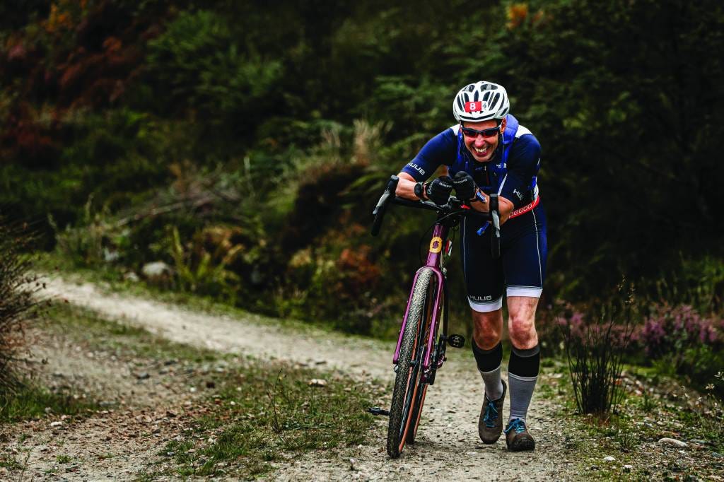 cyclist pushing bike on trail