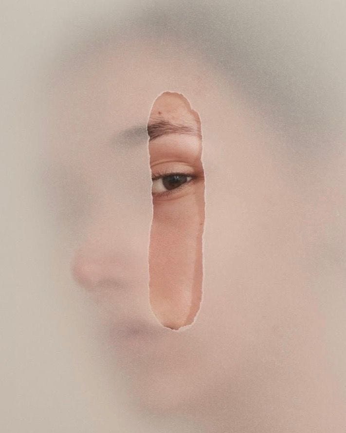 This may contain: a woman's face is shown through a hole in the paper