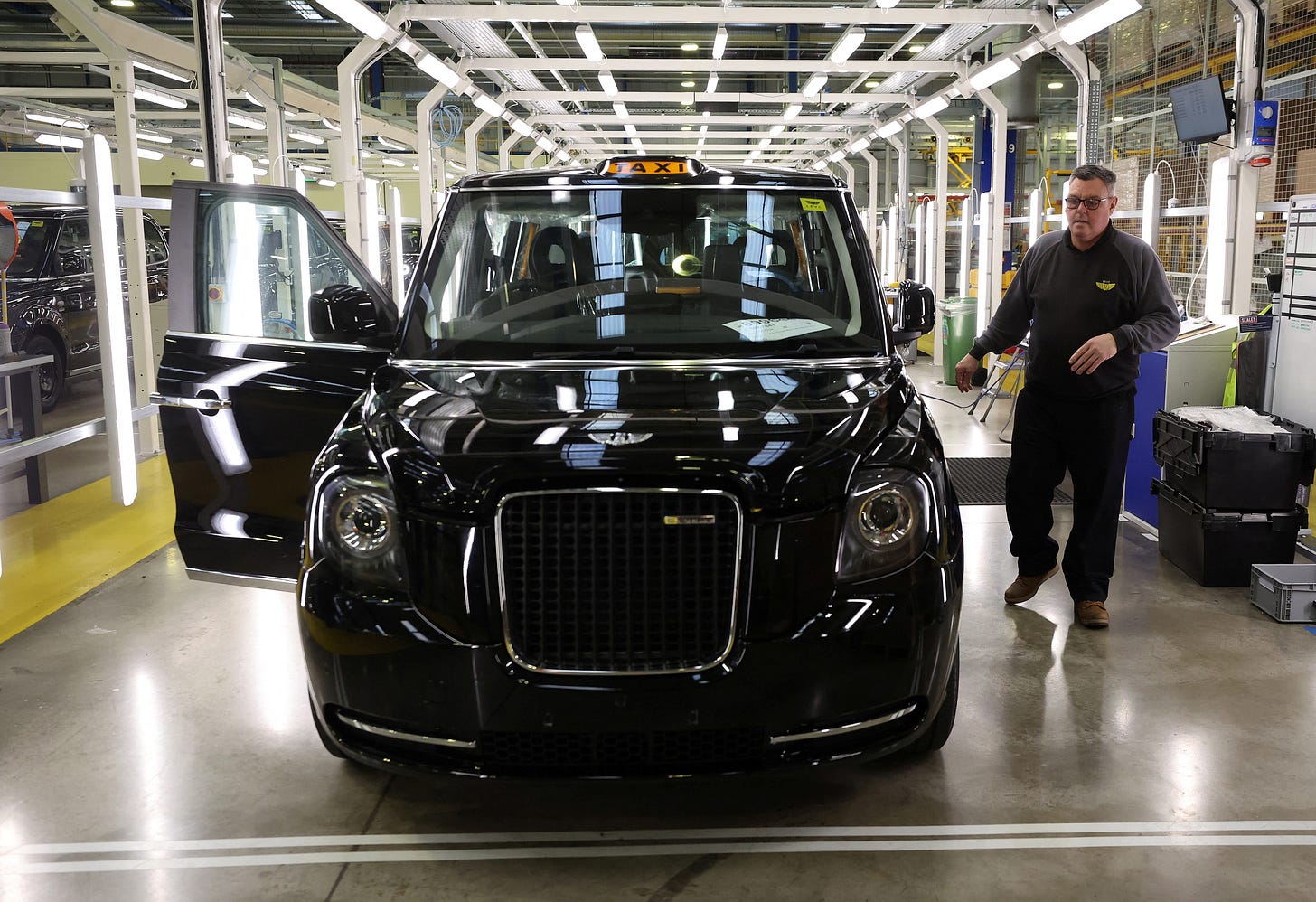 A worker walks along the TX electric taxi production line inside the LEVC (London Electric Vehicle Company) factory in Coventry