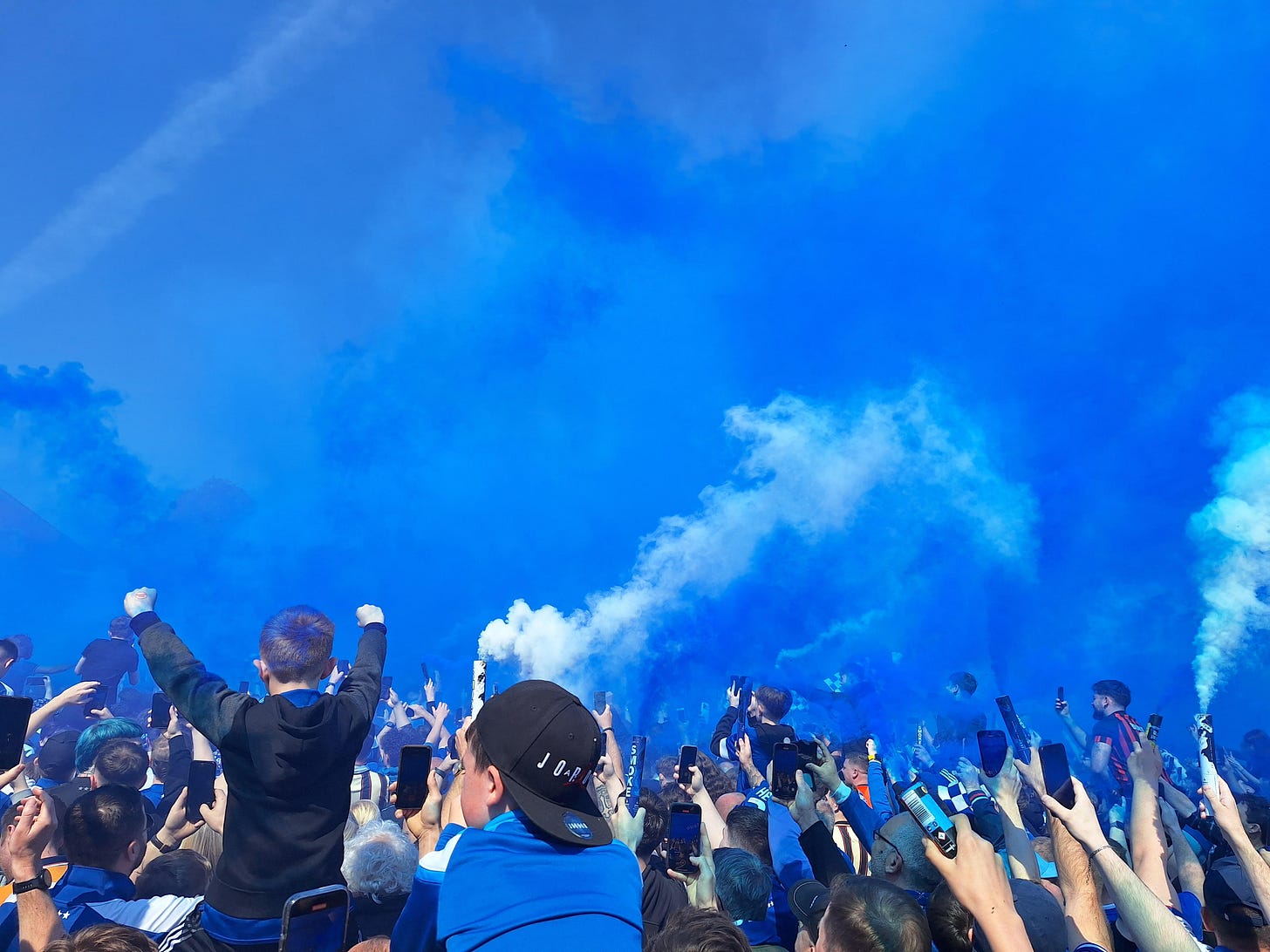blue and white smoke fills the air ahead of the Ipswich coach arriving before the home game with Huddersfield