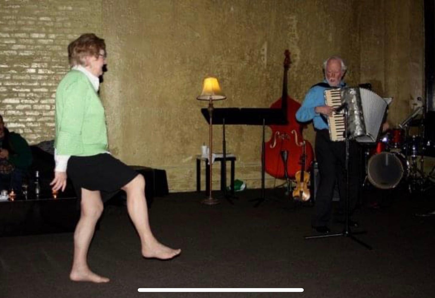 Woman dancing a jig while a man plays a piano accordion