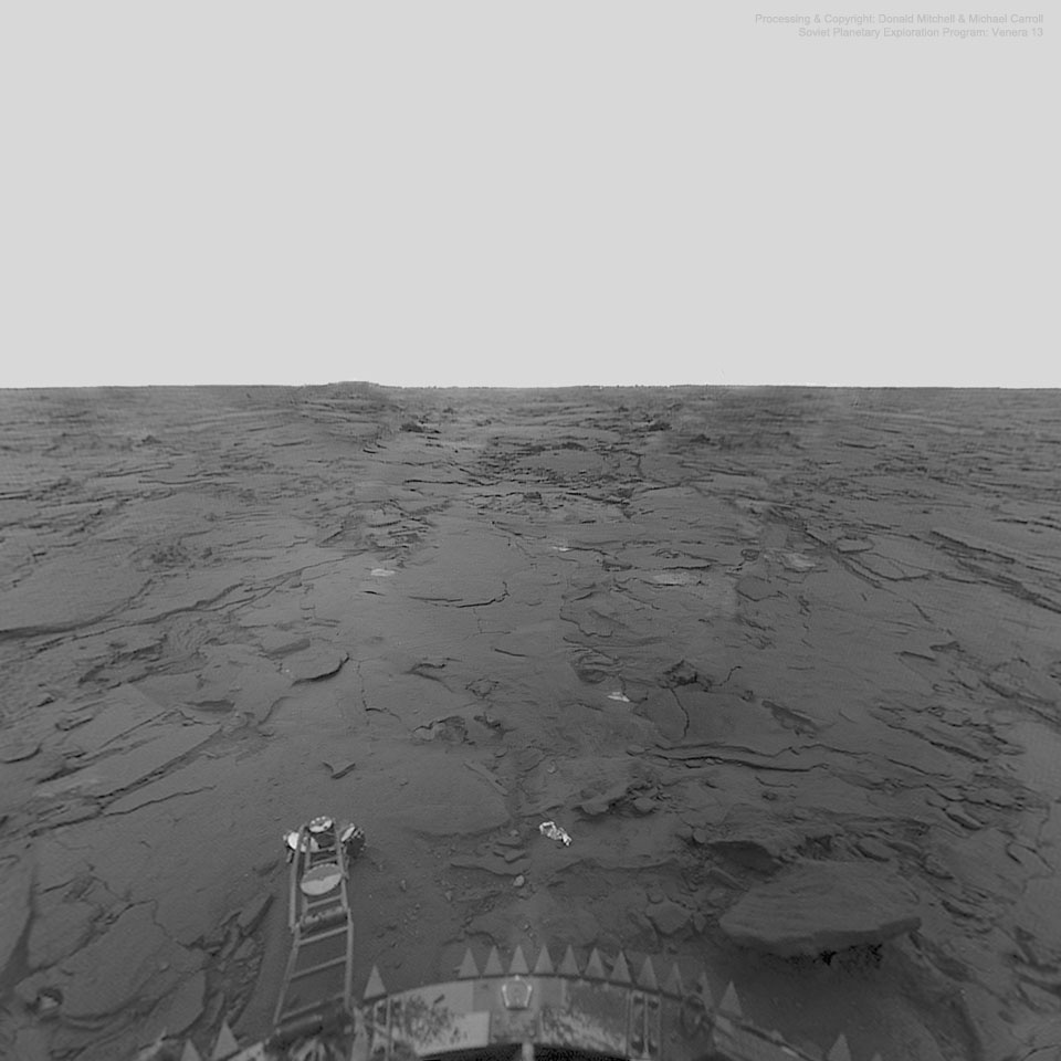 A black & white image shows an empty flat landscape filled
with flattened rocks. At the bottom is part of the spacecraft
that captured this image of the planet Venus.
Please see the explanation for more detailed information.