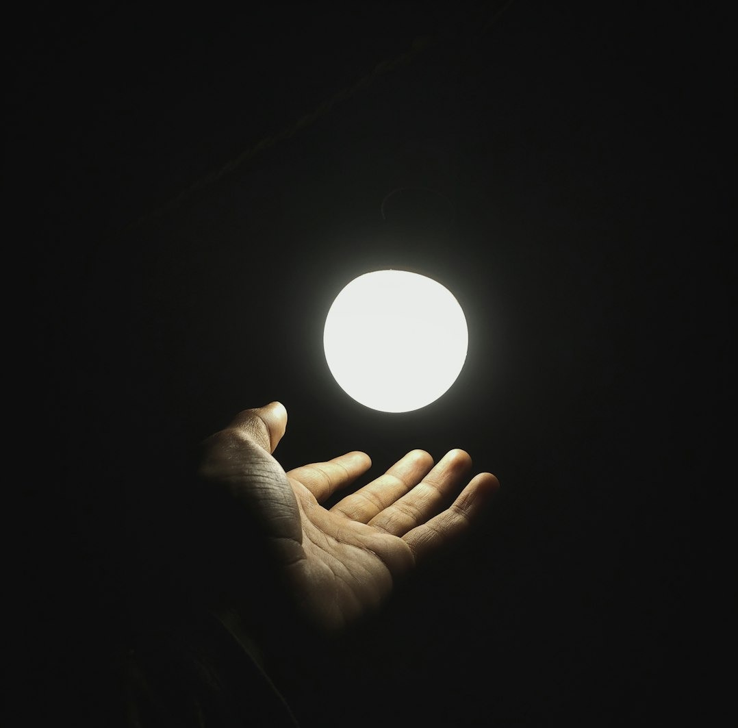 a hand holding a light in the dark a hand holding a light in the dark
