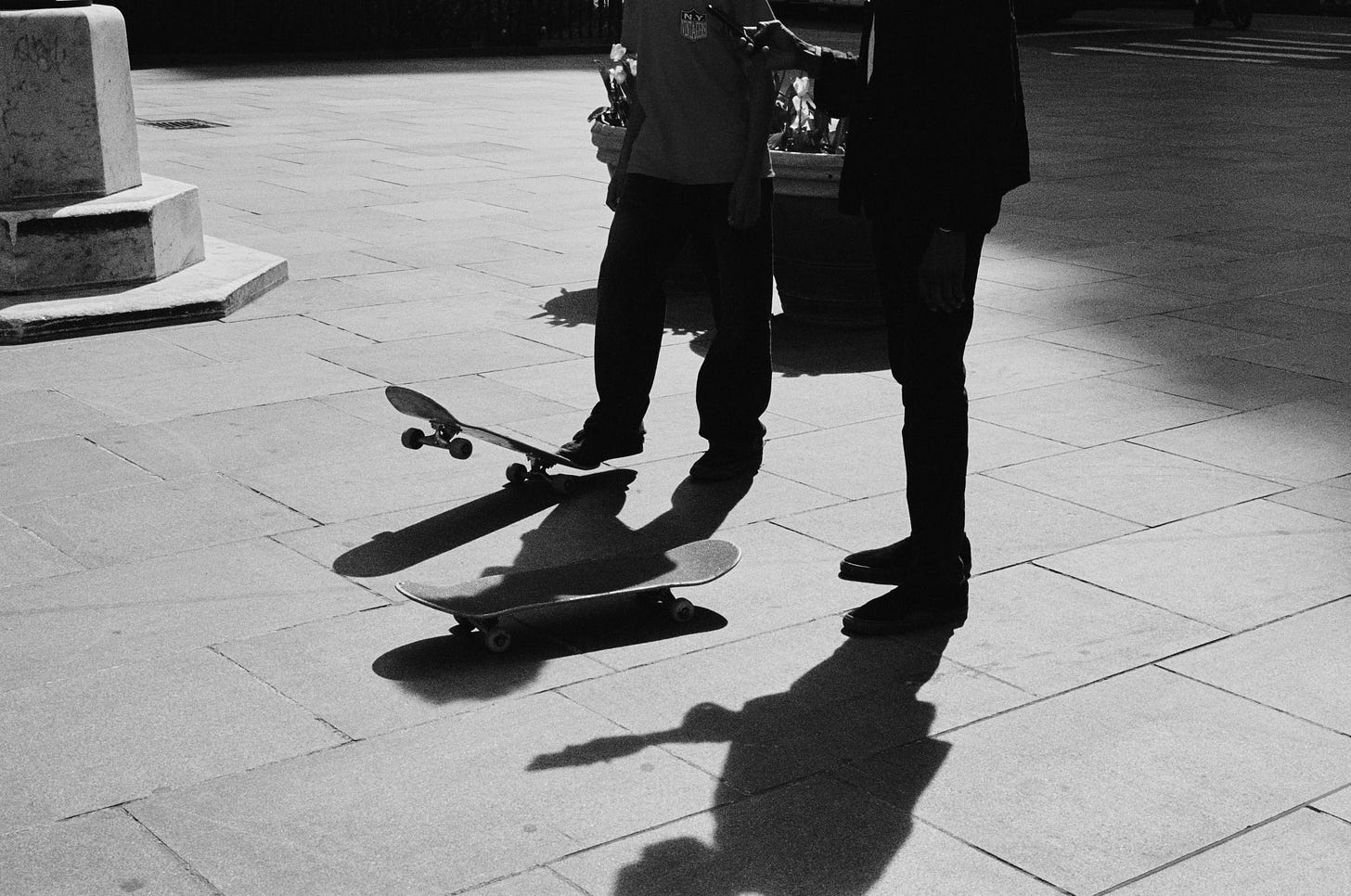 A father and his son stand alongside one another with skateboards beneath their feet