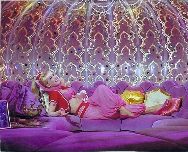 This may contain: a woman laying on top of a purple couch in front of a wall with lights