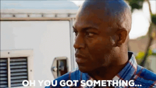 a man in a plaid shirt is standing in front of a white van and saying `` oh you got something ... ''