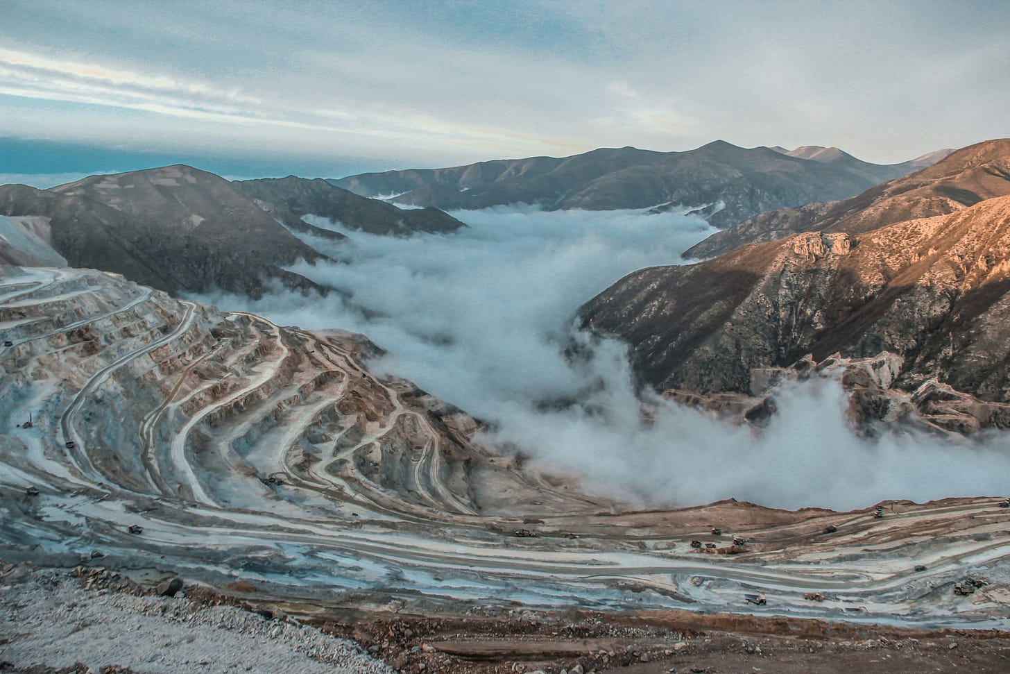 An open-pit mine with a cloud in it An open-pit mine with a cloud in it