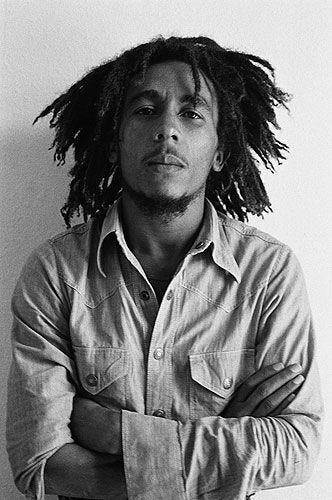 This may contain: a black and white photo of a man with dreadlocks