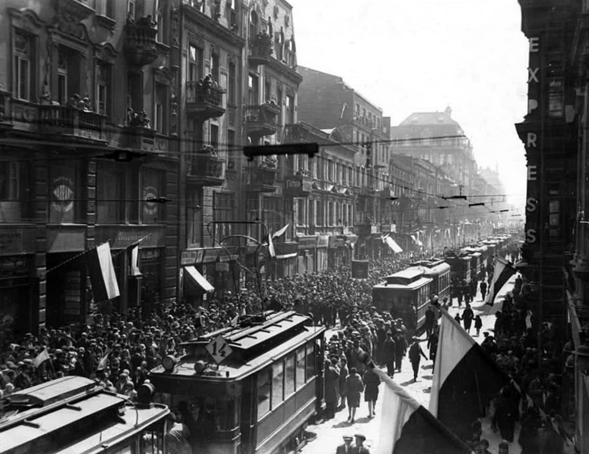 A vibrant Constitution Day parade on Piotrkowska Street in Łódź, Poland, celebrating the May 3rd Constitution in 1929.