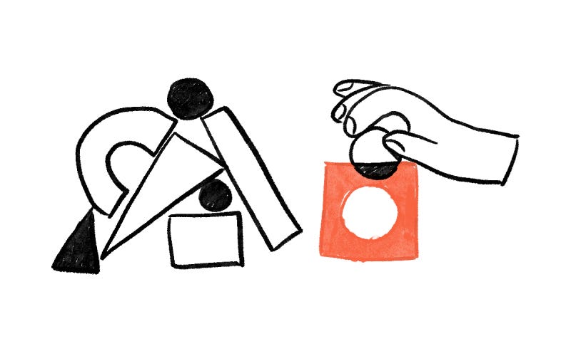 A bunch of unrelated shapes on the left; A hand holding a circle and is placing it in the red square with a matching round hole inside. Plain white background.