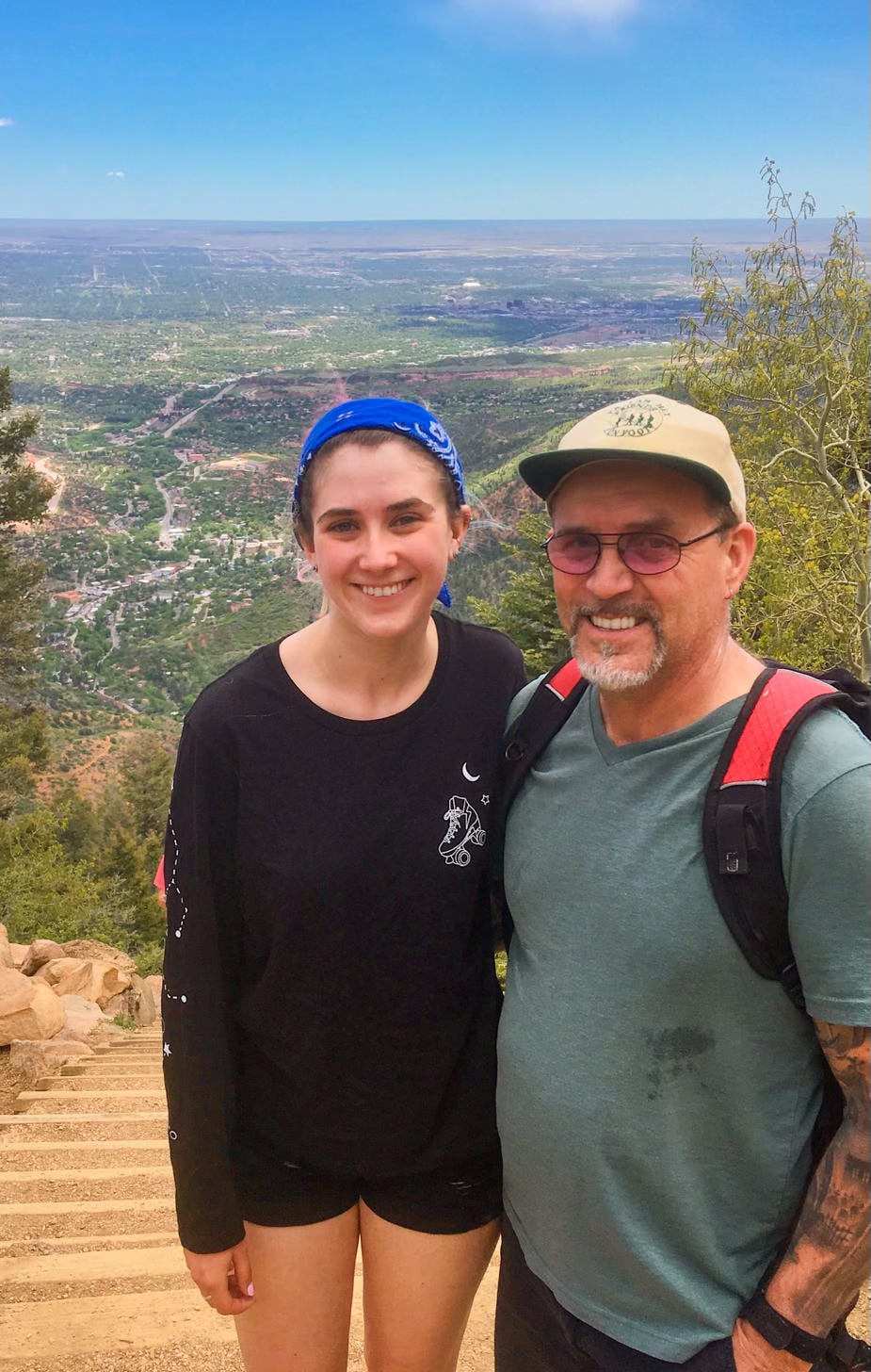 Young woman and older man at summit of hiking trail