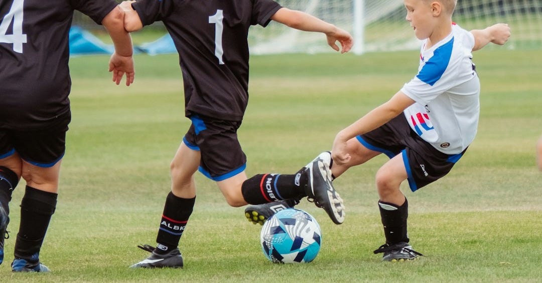 2 men playing soccer during daytime