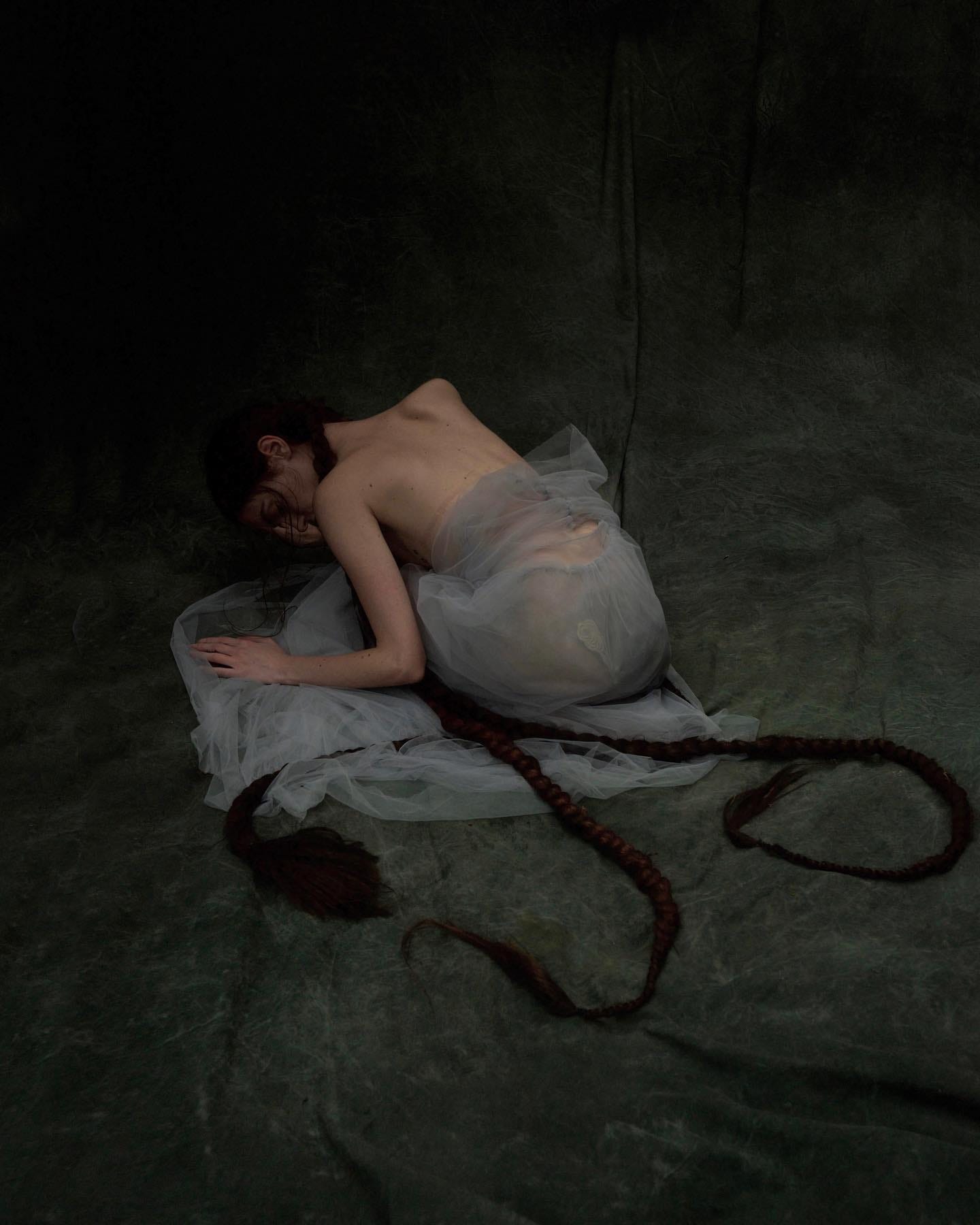 A woman slumped over in shadow, symbolizing the process of letting go of the past